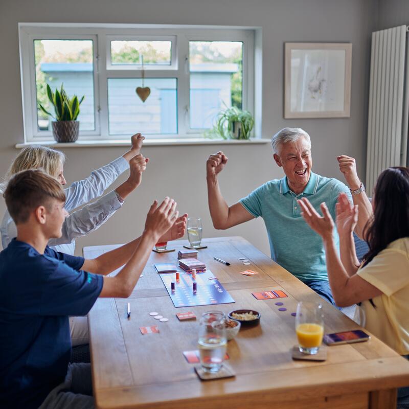 Popmaster board game lifestyle image four people celebrating winning