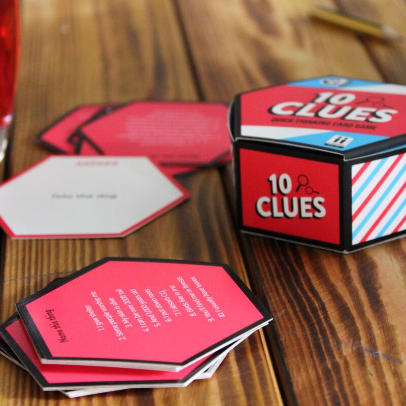 Ginger Fox 10 Clues travel-sized family card game on a wooden table with question cards scattered
